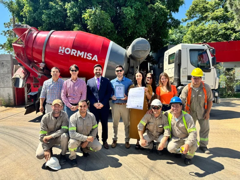 Entrega de certificado al equipo de una planta de hormigón, junto al camión mixer